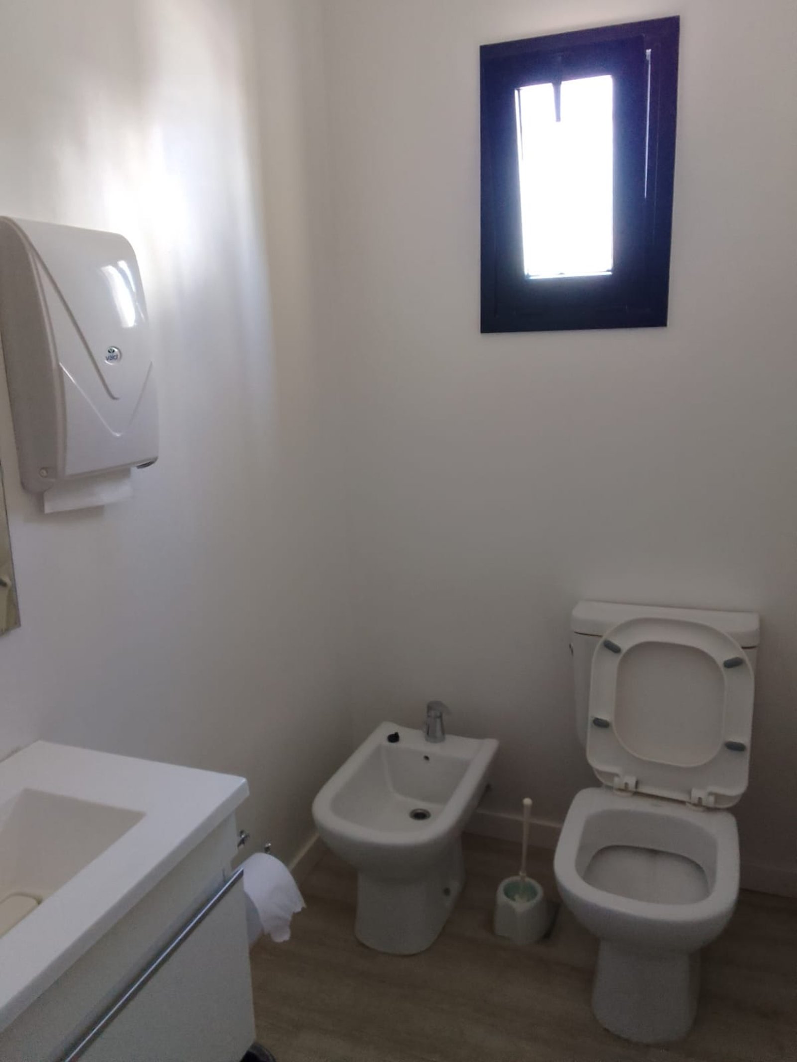 Baño minimalista con bidet, inodoro y dispensador — proyecto Drogueria en Avellaneda, por Arquitecto Guido Niccoli, en B1872 Sarandí